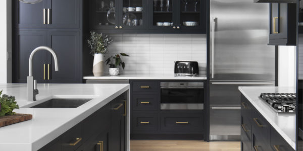 modern-kitchen-white-countertop-dark-cabinet-brushed-gold-accents-stainless-steel