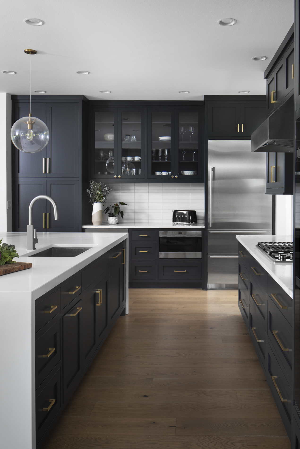 modern-kitchen-white-countertop-dark-cabinet-brushed-gold-accents