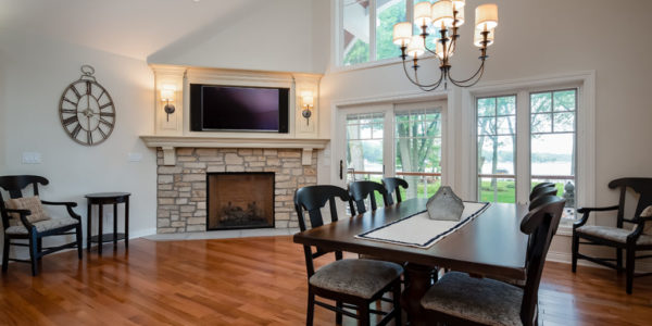 open-concept-dining-room-fireplace-dark-wood-natural-light