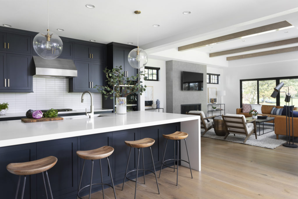 open-concept-kitchen-dark-cabinets-lakefront-home-glass-pendant-lights-brushed-gold