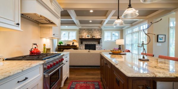 open-concept-kitchen-living-room-wood-beams-white-cabinets