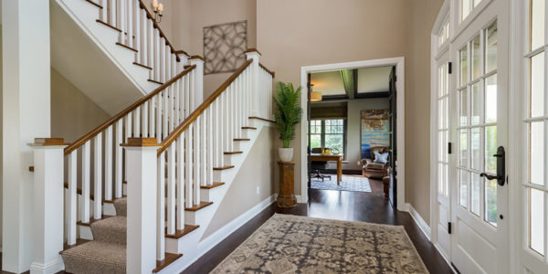 white-stained-wood-grand-staircase-entryway-dark-floors